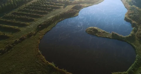 A river in the middle of a green plain reflecting sunlight. Stock Footage 114437170