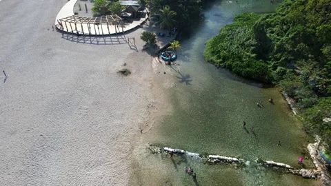 River mouth with a gazebo structure and people in the water, aerial view Stock Footage 278368995