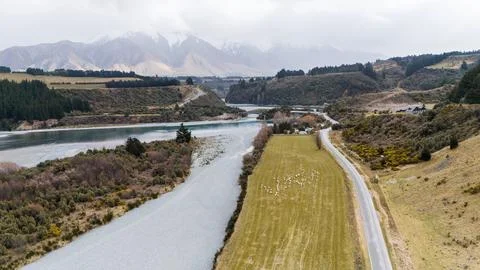 River mouth surrounded by fields located in valley among mountains Stock Photos
