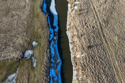 River narew flowing through fields with melting snow Stock Photos