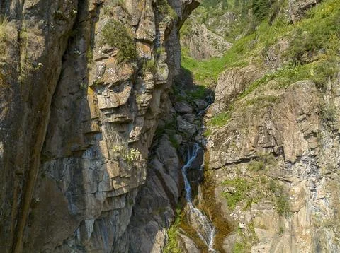 River or stream flowing through rocky cliffs with green vegetation Foto stock