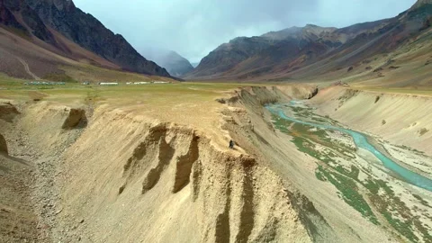 River Overlooking Rugged Canyon. Curving Water Flows Canyon. Traveler on Stock Footage 339341638