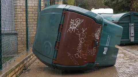 The river overturned the garbage container. Stock Photos