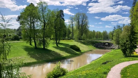 River in the park on a sunny spring day. white clouds float across the blue sky Stock Footage 134475206