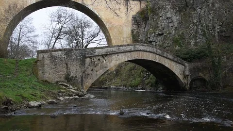 A river passes under two old bridges Stock Footage 70918901