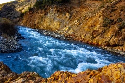 The river passes very quickly and takes everything it sees, dark blue water Stock Photos