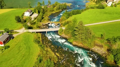 River passing through green meadows and bridges, Aerial view in 4k Stock Footage 166953244