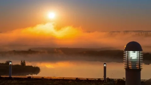 River pier with burning lanterns against timelapse of Moving Fog on the River Stock Footage 75328753