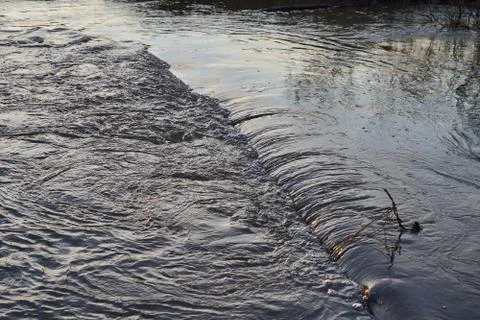 River with a rapid flow in the spring at sunset Stock Photos