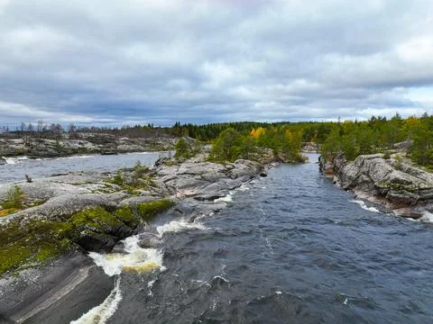 River rapids flowing between rugged, mossy rock formations Stock Photos