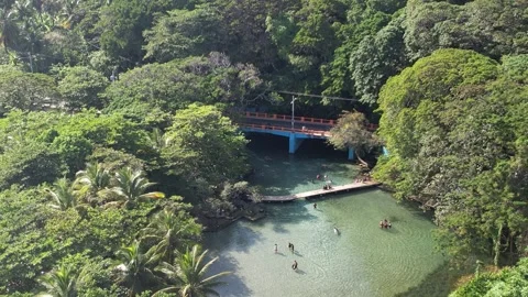 River with a red pedestrian bridge and people wading, aerial view Stockbeeldmateriaal 278369438