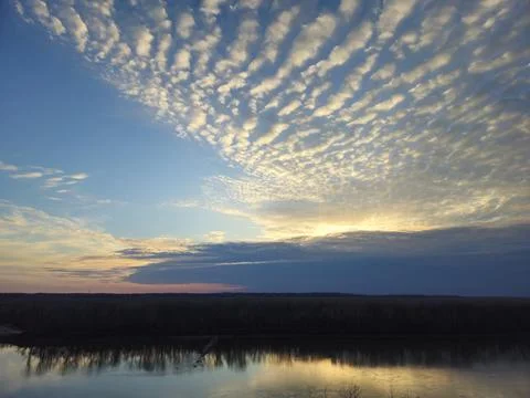 River Reflection and Altocumulus Clouds at Sunrise or Sunset Foto stock