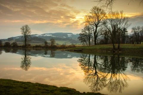 River reflection of trees on a golden sun Stock Photos