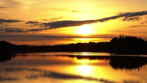 River reflections of clouds in a golden sky drifting past partial solar Stock Footage 155630566