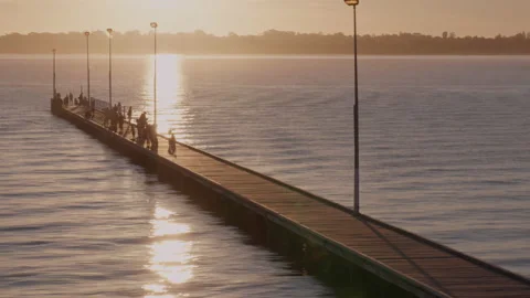 River reflections of low sun features jetty - time lapse - silhouettes of people Stock-Footage 151659231