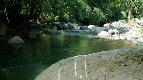 A river with a rock in the middle of it Stock Photos