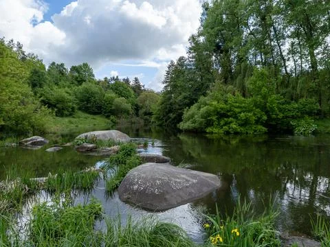 A river with rocks in the middle of it surrounded by trees Stock Photos