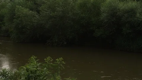 A river running slowly at the outskirts of a small town Video stock 94088352