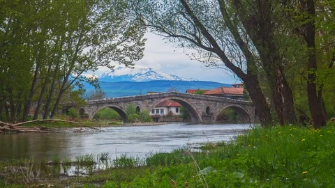 A River Running Towards the Mountain Through a Bridge Stock Footage 119221185