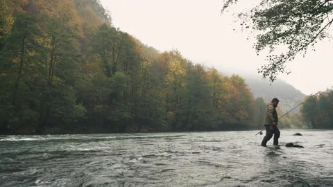 River Sana, Bosnia, 16 August 2018: A man with a fishing rod in his hand crosses Video stock 141508341