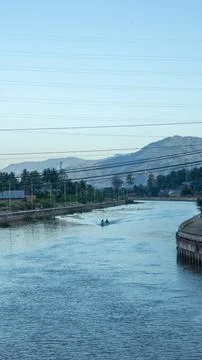 River Scene with Distant Mountains and Boats Stock Photos