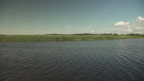River scene with meadows in the opposite side in a windy sunny day Stock Footage 161152854