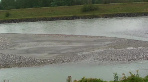 River with sediments on its riverbed and high levees, pan right Stock Footage 49769416