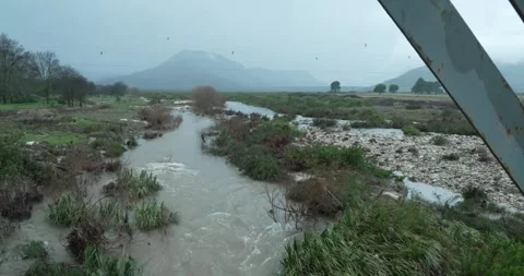 River from small bridge with mountain in background Stock Footage 277389789