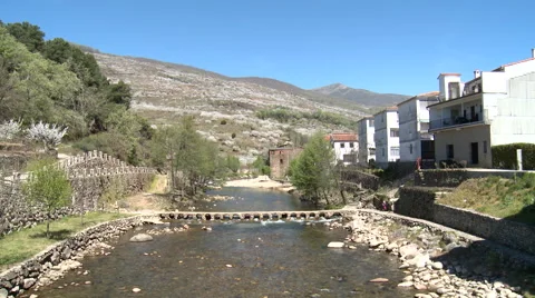 River with a small crossing between village and cherry plantations, Tilt down Stock Footage 49552988