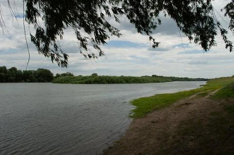 A river with small waves in the wind in cloudy weather Stock Photos