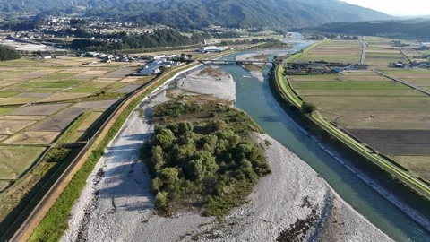 River Split Around a Broad Gravel Island in a Farm Valley 스톡 동영상 347928411