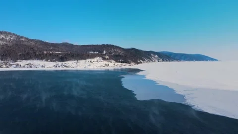 The river is split in half by ice. Vapour rises over the water. Drone footage Stock Footage 220004169
