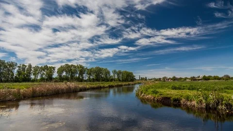 River in spring on a bright sunny day. Blue sky with white clouds Stock Footage 75780741