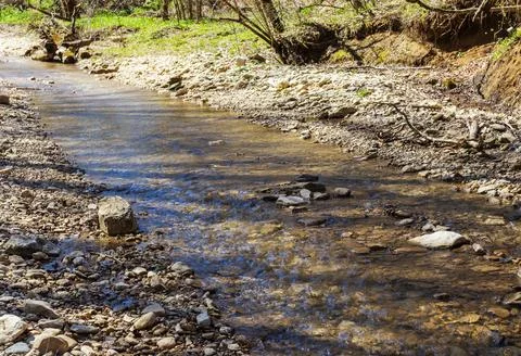 The river in the spring of the year, a slow flow along a shallow riverbed Stock Photos