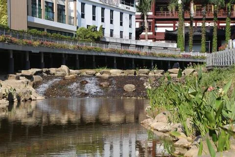 A river with a stone wall on the side Stock Photos