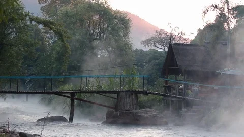 River stream flowing and vaporizing in morning and bamboo bridge over the river. Stock Footage 121090903