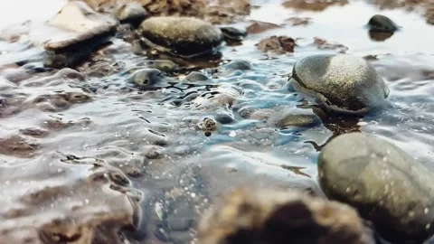 River stream flowing water in slow motion with pebbles 動画素材 344095517
