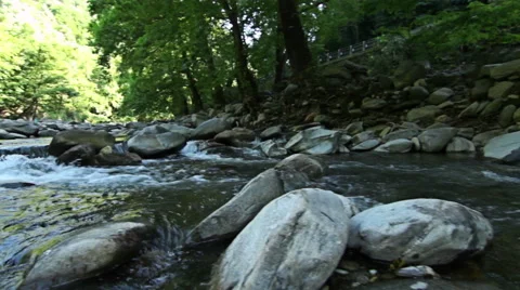 A river stream flows over rocks in this beautiful mountains scene Stock-Footage 52627978