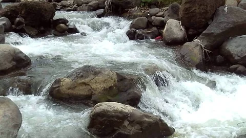 A river stream with its water overflowing in the mountain Stock Footage 127494546