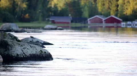 River streaming peacefully on a summer evening, boathouses in the background Stock Footage 68724587
