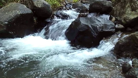 River streams among big black stones and become some small waterfall Stock Footage 124773457