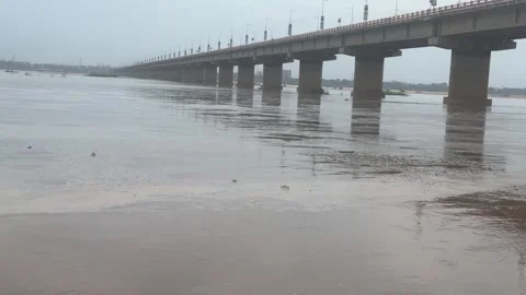 River with Strong Current Flow Beneath Long Concrete Bridge Stock Footage 340499530