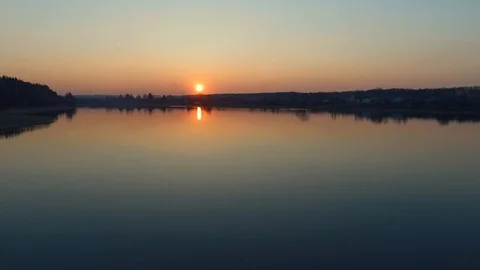 River in sunset. Low flight of the drone over the smooth surface of the water  Stock Footage 107807819