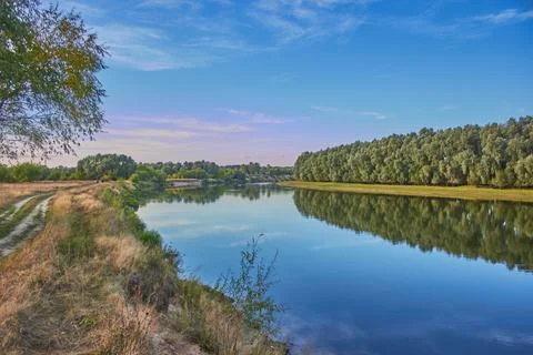 A river surrounded by fields and trees Stock Photos