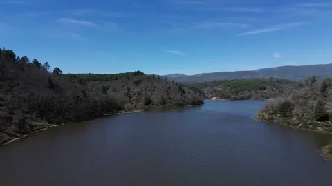 A river surrounded by trees and mountains Stock Footage 328615640