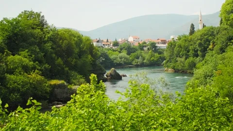 River surrounded by trees crossing the beautiful city of Mostar, in Bosnia Stock Footage 241678478