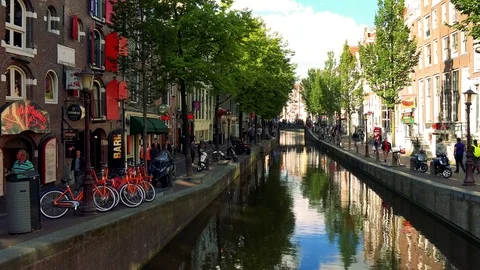 A river in a traditionally looking town, trees and buildings on the sides, the Stock-Footage 73958286