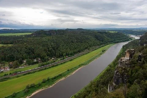 A river with a train passing by Stock Photos