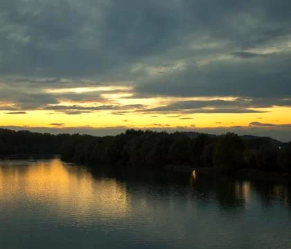 River under sunset light, clouds Stock Photos