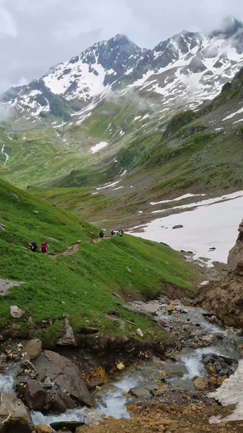 River in Val Ferret valley in Italy, with overcast sky and rocky mountain range Stock Footage 283928341